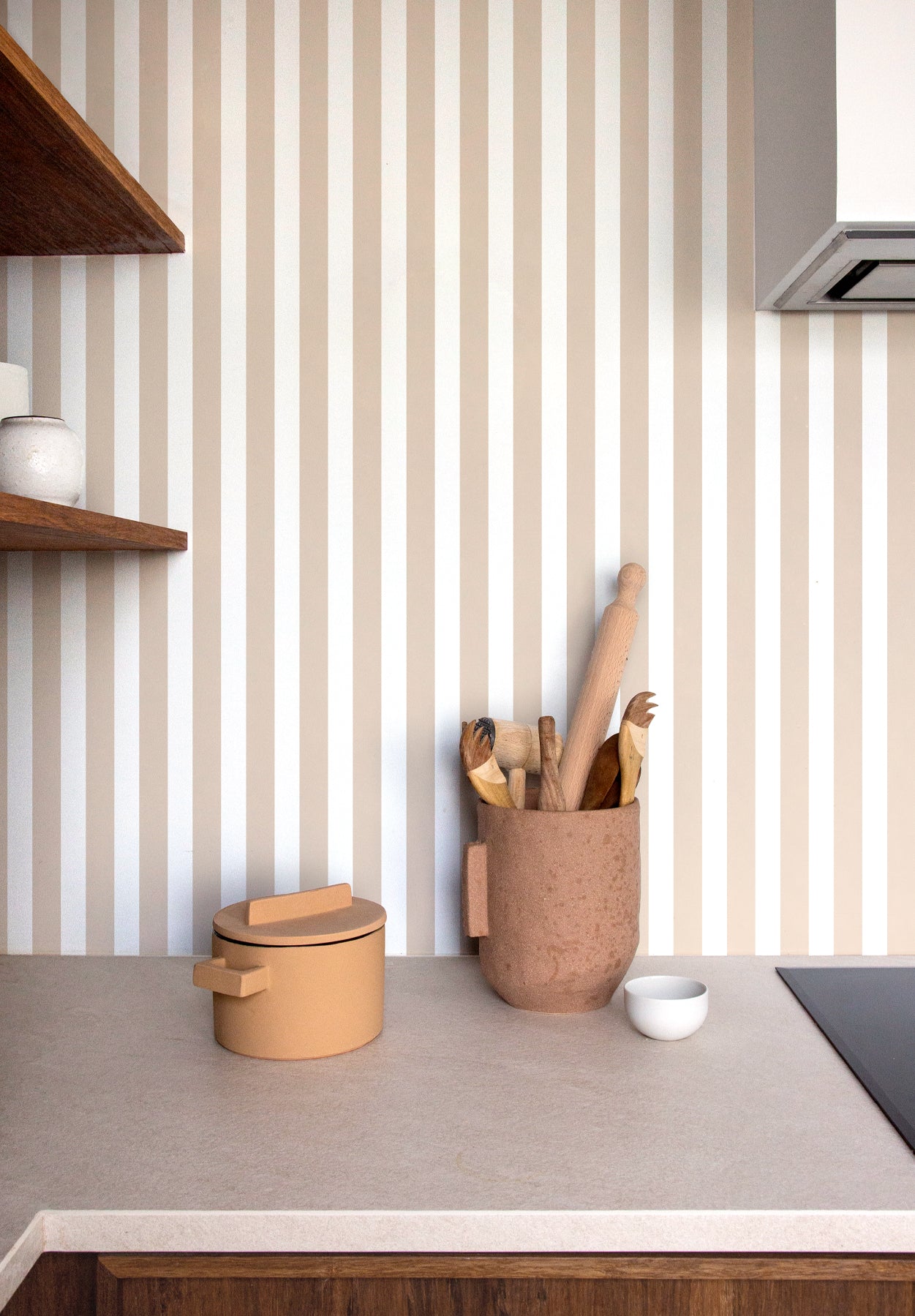 Papier peint à rayures verticales terracotta et beige dans un intérieur minimaliste